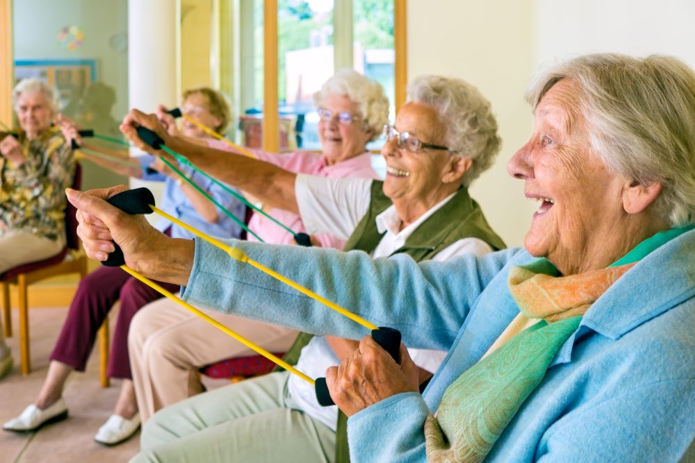 Nursing home residents are doing exercises with stretch bands.